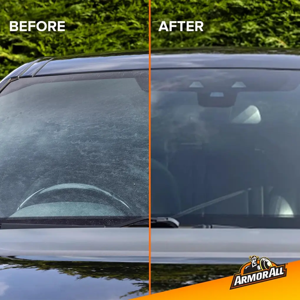 A hand cleaning a car window with an Armor All Glass Wipe
