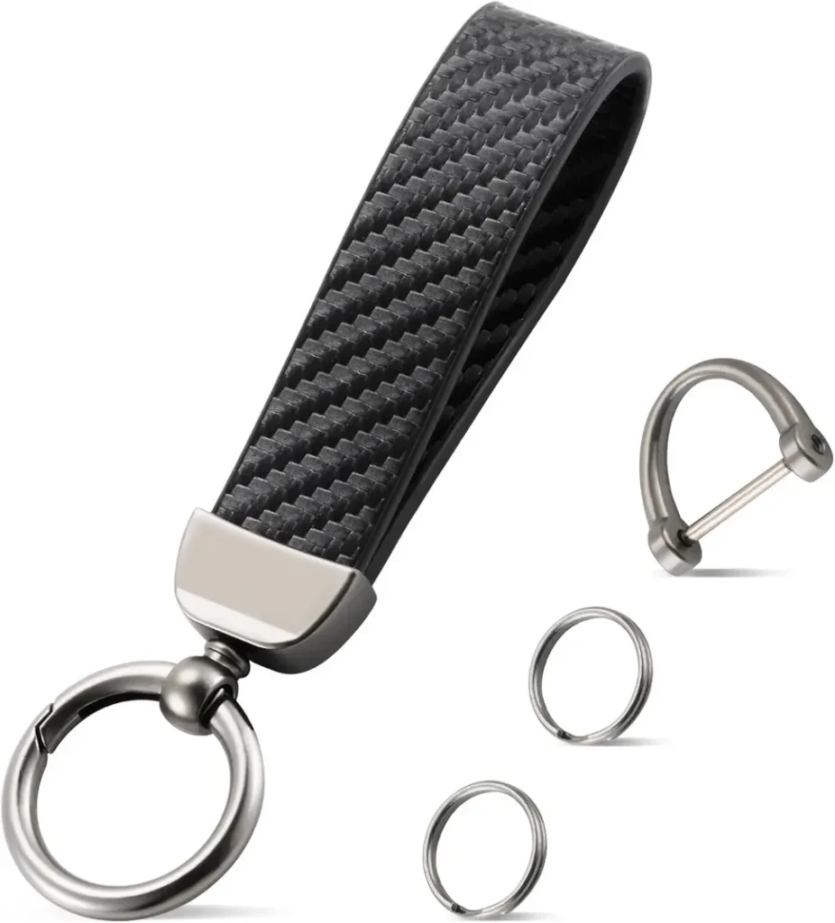 JUSTTOP Leather Keychain in black carbon fiber style next to car keys on a wooden desk