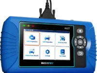 BLCKTEC 460T OBD2 Scanner displayed on a garage workbench with car parts in the background