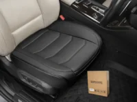 A BOPUOVRE Car Seat Cover in black, installed in a car, with its box nearby.