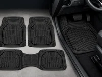 Black all-weather car floor mats arranged beside a mat installed in a vehicle’s driver-side footwell.